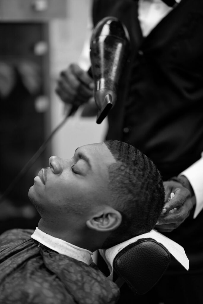 Barber styling a client at Max-U Barber Salon in Brooklyn, NY